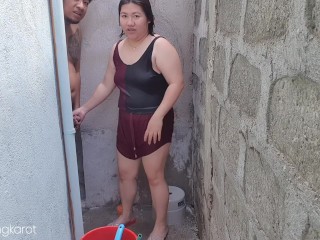 פיליפינית מתרחצת מחוץ לבית התבאסה